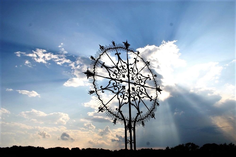 The wrought-iron Resurrection Cross at the heart of the cemetery